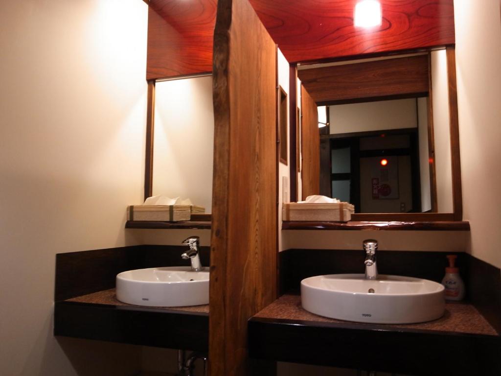 une salle de bain avec deux lavabos et un miroir dans l'établissement Minshuku Takizawa, à Takayama