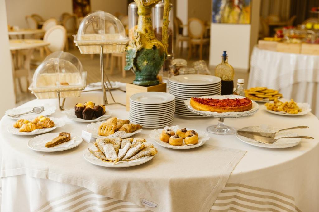 une table blanche avec des assiettes de nourriture dessus dans l'établissement Hotel Puglia Garden, à Vieste