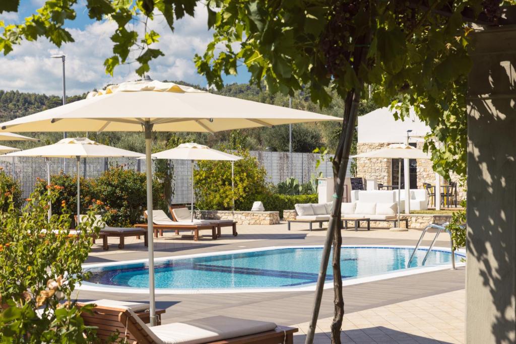 une piscine avec parasols et chaises et une piscine dans l'établissement Hotel Puglia Garden, à Vieste