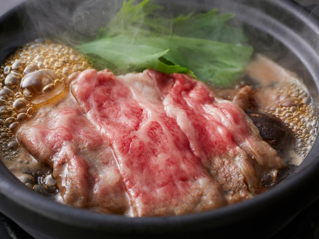 un gros plan d'un bol de nourriture avec de la viande dans l'établissement KAMENOI HOTEL Arima, à Kobe