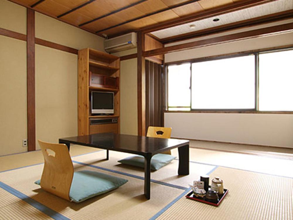 un salon avec une table et des chaises noires dans l'établissement Schole Hakuba, à Hakuba