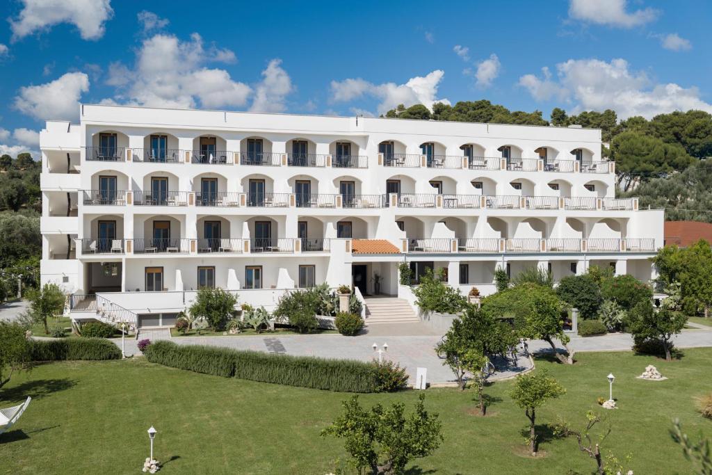 un grand bâtiment blanc avec un jardin devant dans l'établissement Hotel Puglia Garden, à Vieste