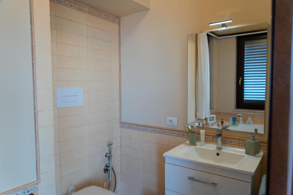 une salle de bain avec un lavabo, des toilettes et un miroir dans l'établissement Villa Vale - with private pool and sea view, à Capo dʼOrlando 36 autres photos