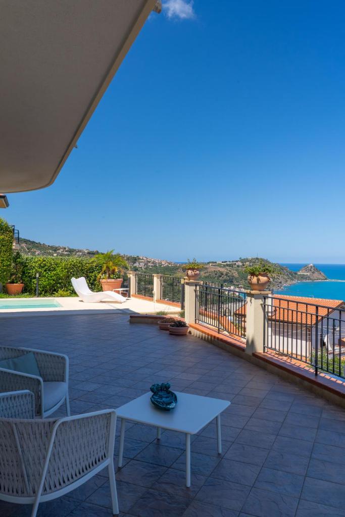 un patio avec une table et des chaises et l'océan dans l'établissement Villa Vale - with private pool and sea view, à Capo dʼOrlando