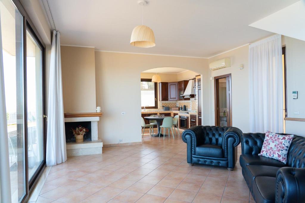 un salon avec un canapé et une cheminée dans l'établissement Villa Vale - with private pool and sea view, à Capo dʼOrlando