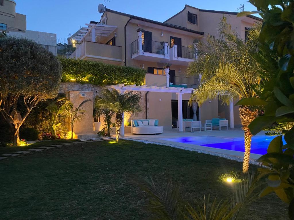 une villa avec une piscine la nuit dans l'établissement Private modern villa in Taormina, à Taormine