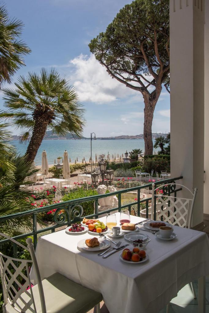une table avec de la nourriture dessus avec vue sur l'océan dans l'établissement Villa Maria Teresa Boutique Hotel, à Formia