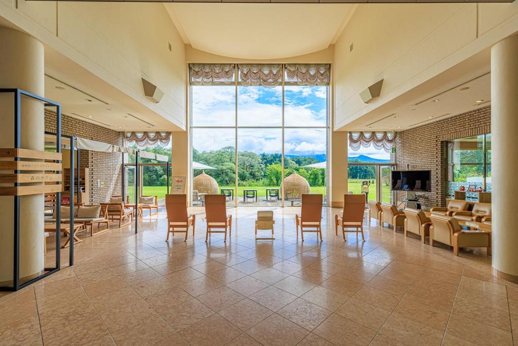 Cette grande chambre dispose de chaises, de tables et d'une grande fenêtre. dans l'établissement Kyukamura Ura-Bandai, à Kitashiobara