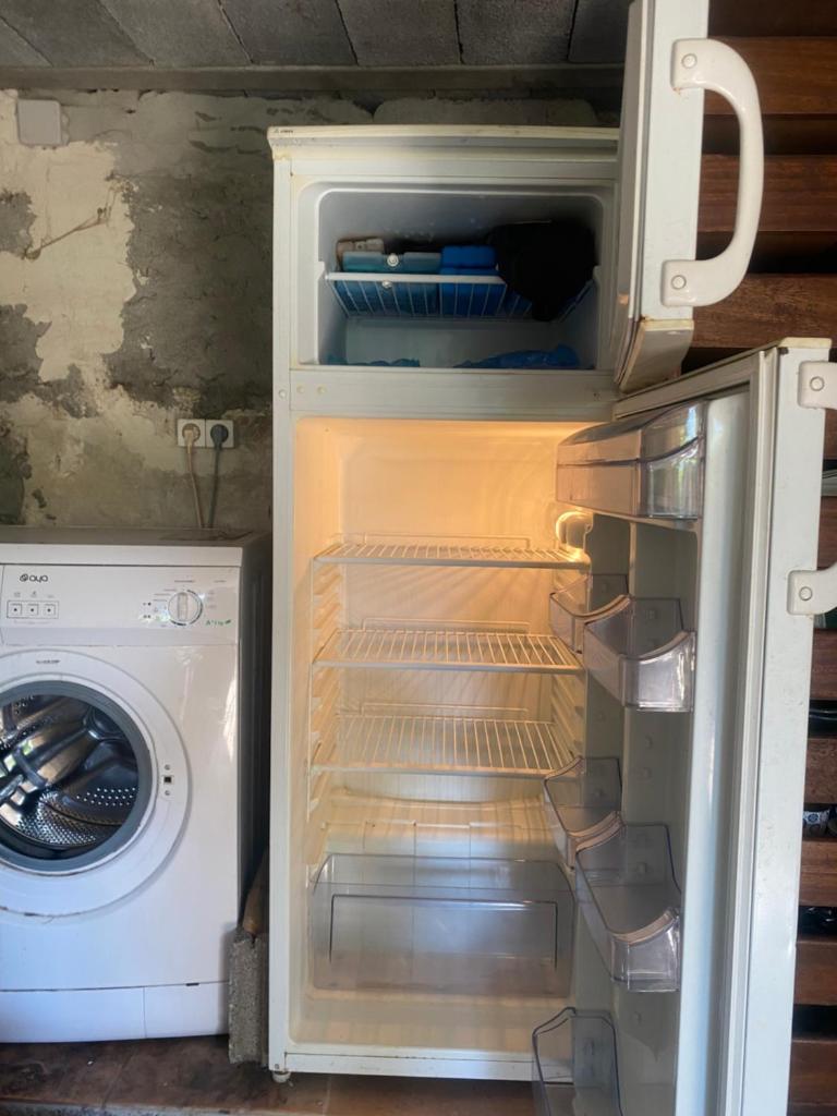 d'un réfrigérateur avec une porte ouverte à côté d'un lave-linge. dans l'établissement Tente pause rando, à Roquestéron