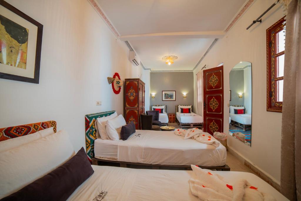 une chambre avec deux lits et un salon dans l'établissement Riad Arabic House & Spa, à Marrakech
