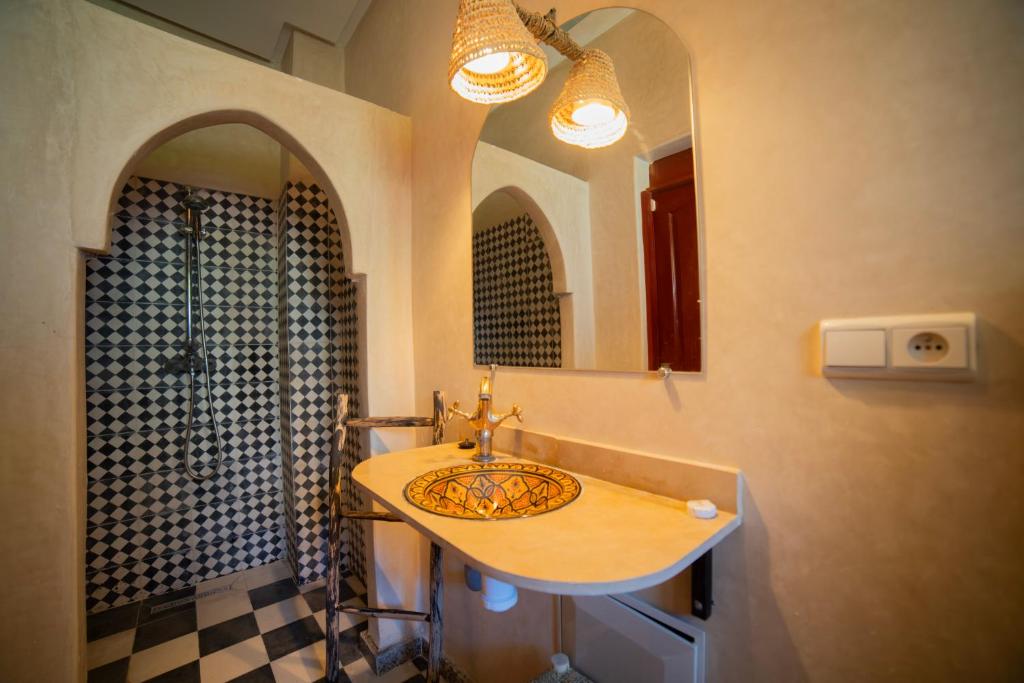 une salle de bain avec un lavabo et un miroir dans l'établissement Riad Arabic House & Spa, à Marrakech