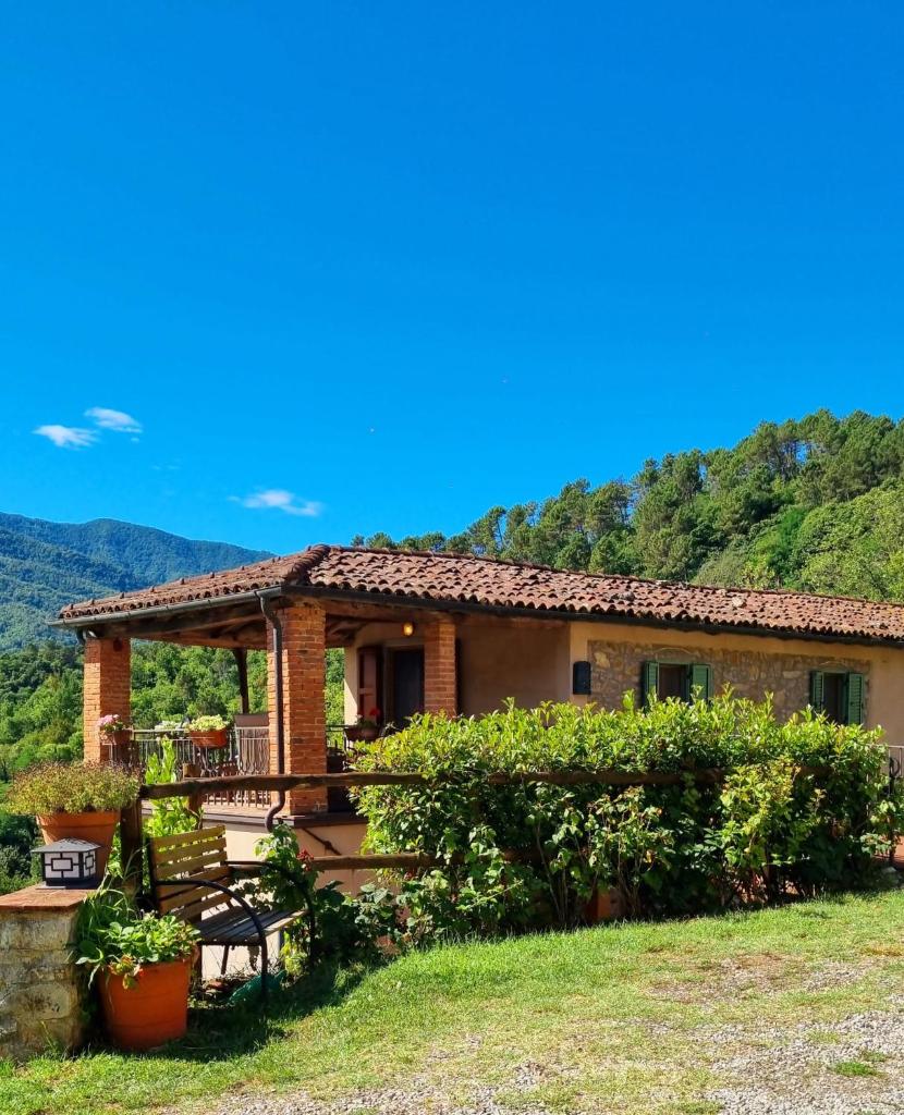 une maison avec une terrasse couverte et des montagnes en arrière-plan dans l'établissement Vicinato Homestead, à Molazzana