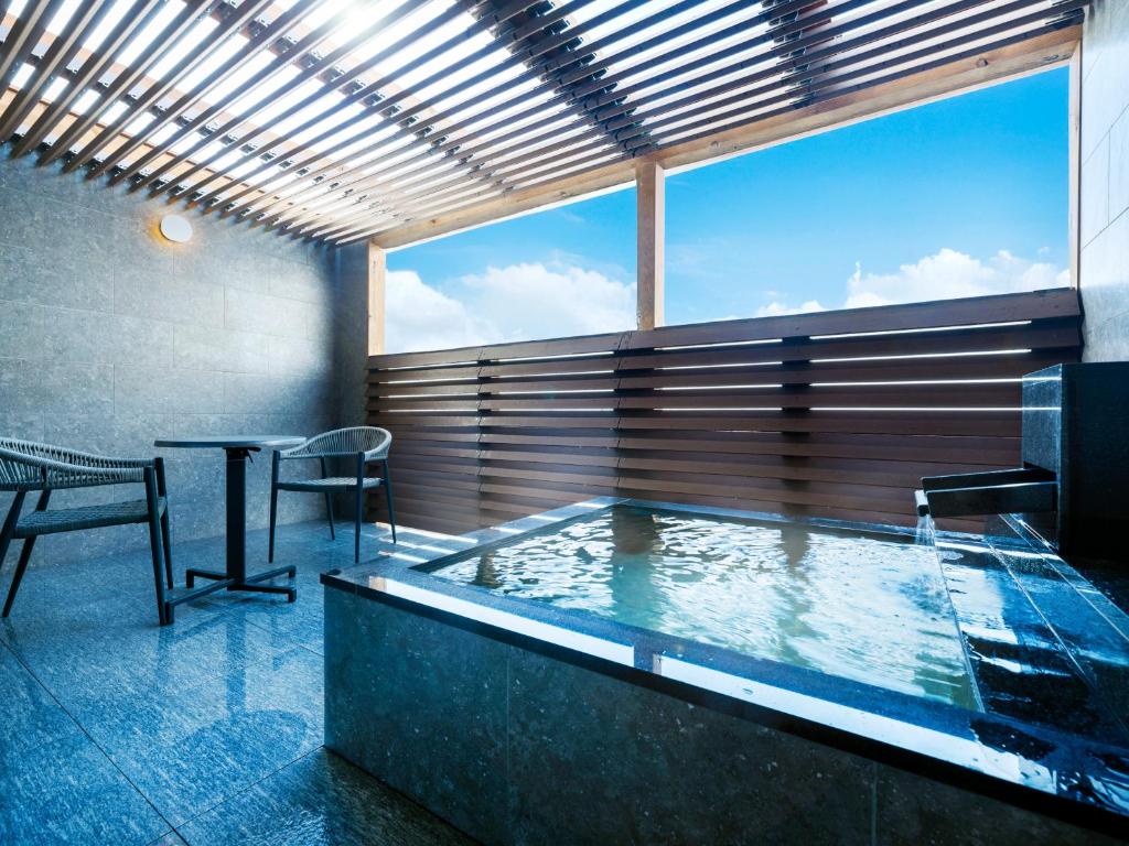 - un bain à remous dans une chambre avec une table dans l'établissement KAMENOI HOTEL Oarai, à Ōarai