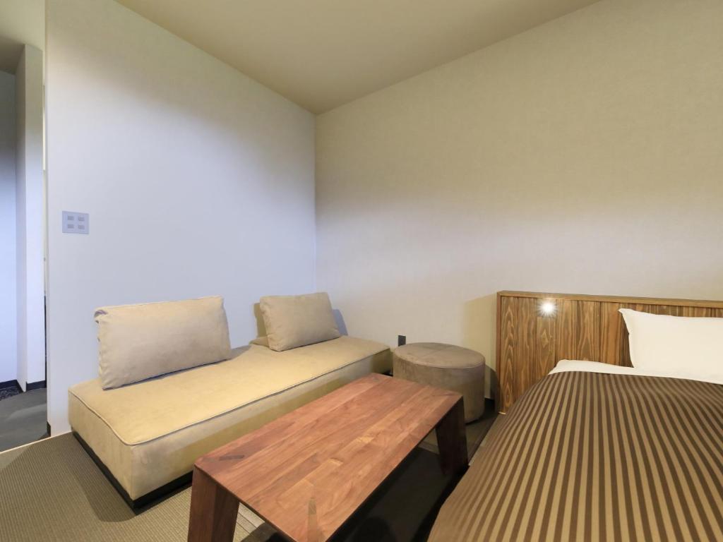 une petite pièce avec un lit et une table dans l'établissement Saga Fuga, à Saga 16 autres photos