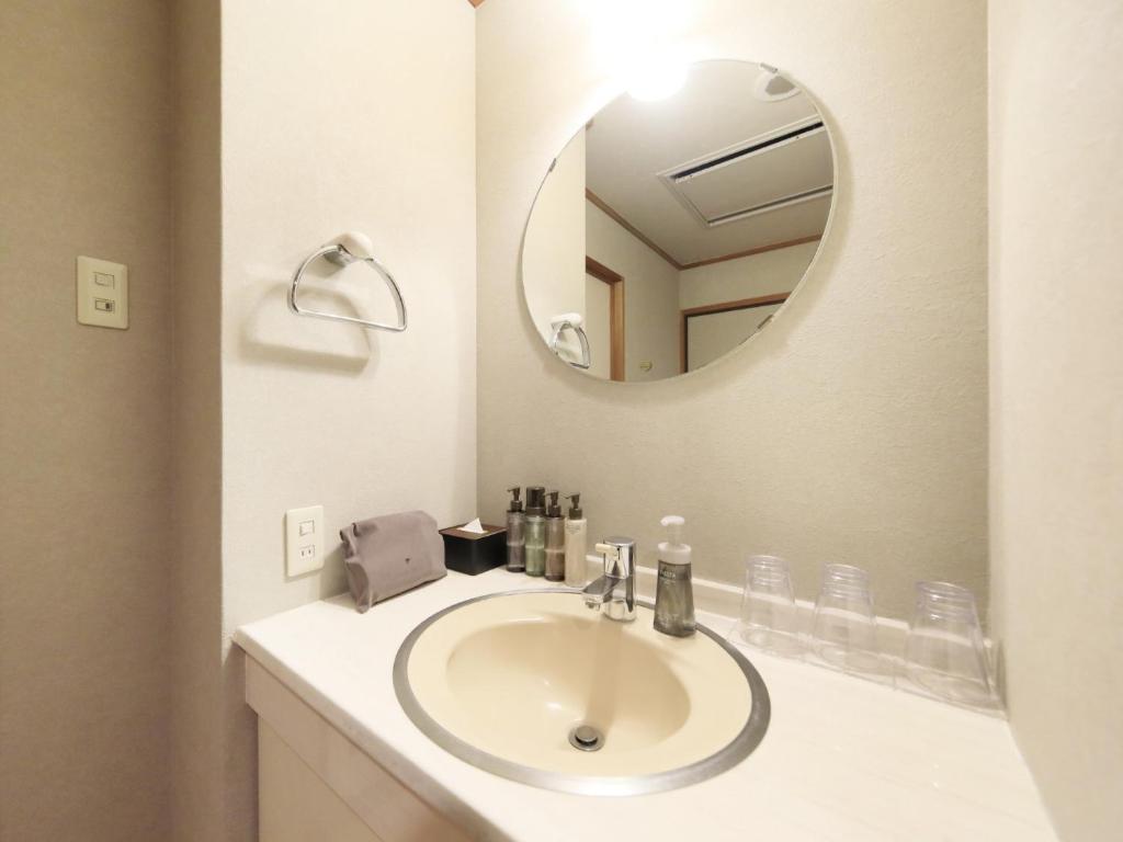 une salle de bain avec un lavabo et un miroir dans l'établissement Saga Fuga, à Saga