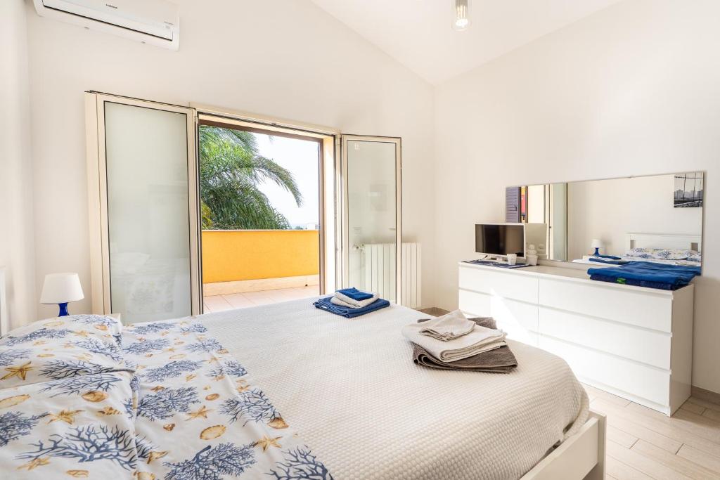 une chambre avec un lit et une grande fenêtre dans l'établissement Villa Uluvud with Pool Gym Sauna, à Alcamo