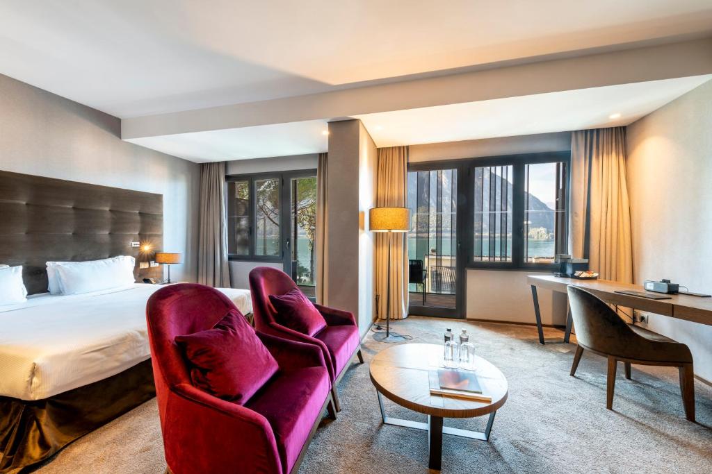 une chambre d'hôtel avec un lit, un bureau et des chaises dans l'établissement Grand Hotel Campione, à Campione dʼItalia