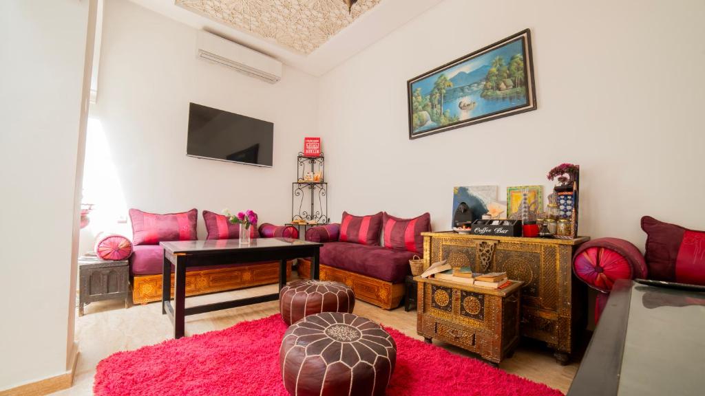 - un salon doté d'un mobilier rouge et d'un tapis rouge dans l'établissement Riad Arabic House & Spa, à Marrakech