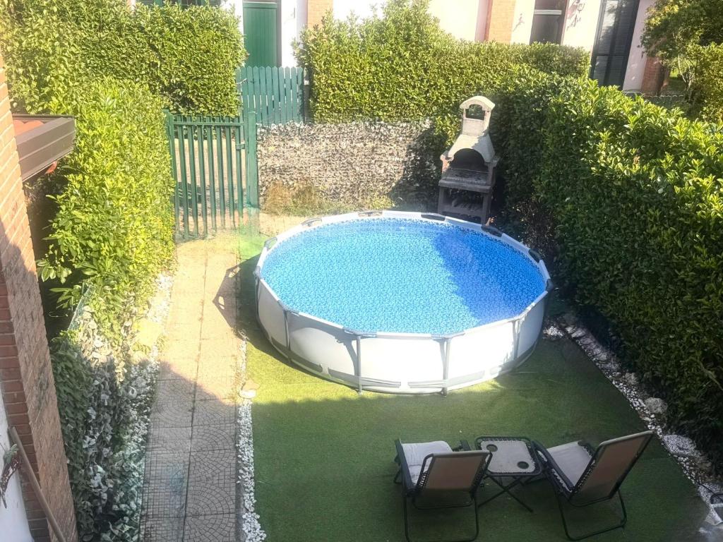 - une piscine avec 2 chaises et une fontaine dans l'établissement Villetta faustina, à Albairate