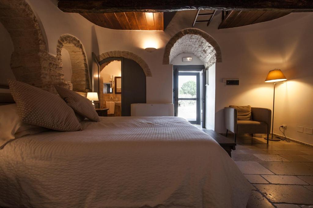 une chambre avec un lit blanc dans une pièce dans l'établissement Grand Hotel la Chiusa di Chietri, à Alberobello