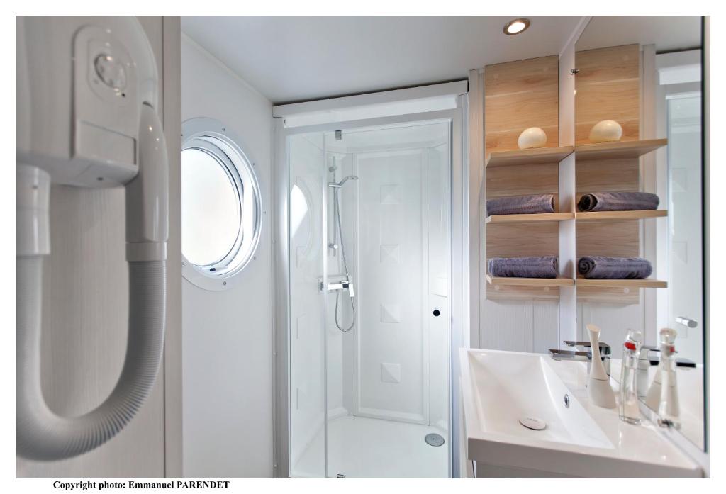 une salle de bain blanche avec une douche et un lavabo dans l'établissement Vic's Land Holidays, à Grimaud