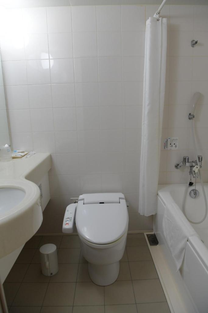 une salle de bain blanche avec toilettes et lavabo dans l'établissement Yuno Yado Shoei, à Kyoto