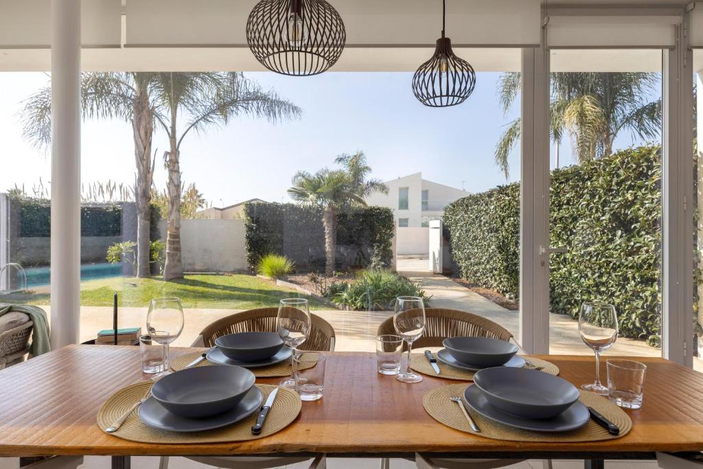 une table en bois avec des verres et des assiettes au-dessus dans l'établissement Villa Platinum, à Raguse