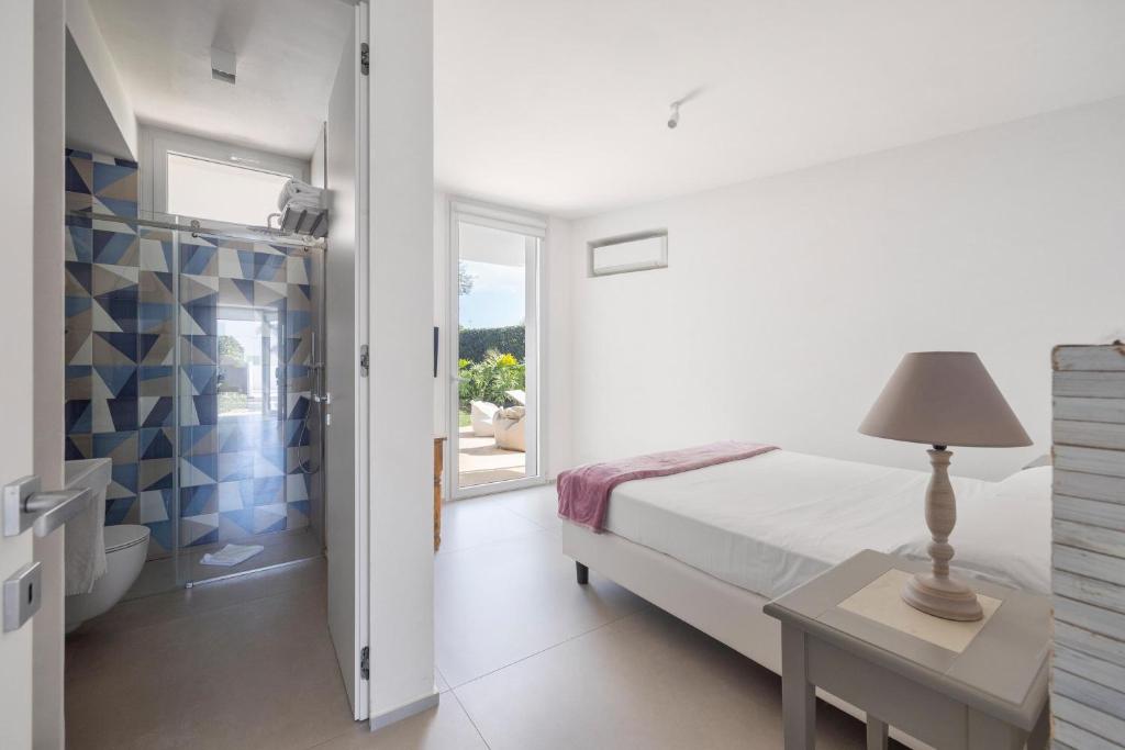 - une chambre blanche avec un lit et une table avec une lampe dans l'établissement Villa Platinum, à Raguse