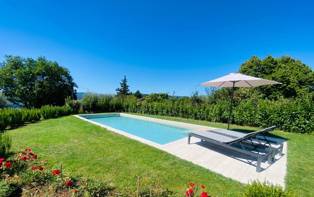 - une piscine avec un banc et un parasol dans l'établissement Villa Angela - Ranza 55, à Lugnano