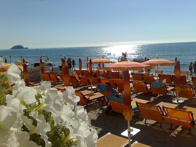 - un bouquet de chaises et de parasols sur une plage dans l'établissement Hotel Gabbiano, à Alassio