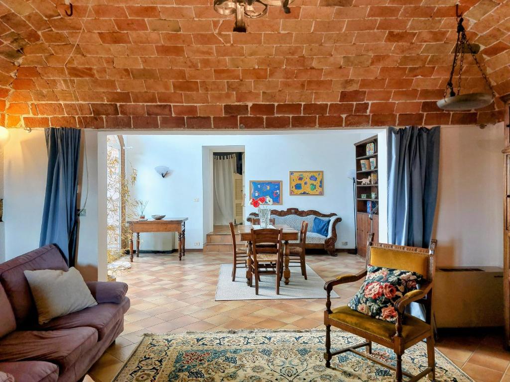 un salon avec un mur de briques dans l'établissement Ca' San Lorenzo - Villa panoramica con piscina - Vignale Monferrato, à San Lorenzo