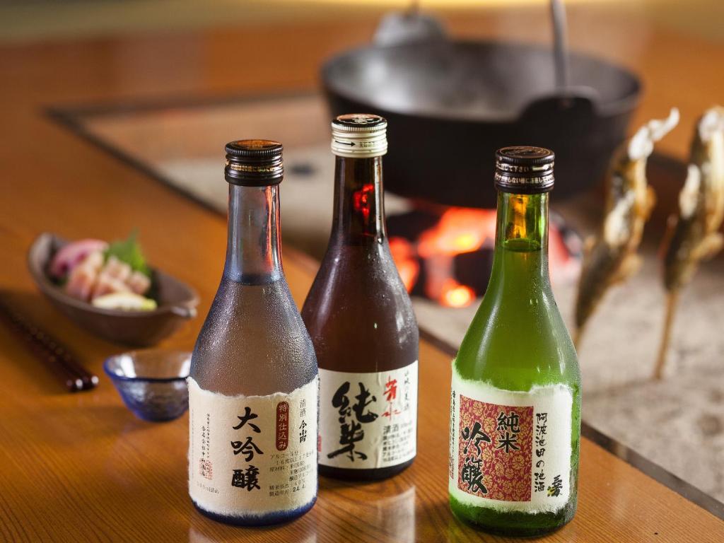 trois bouteilles de vin assises sur une table dans l'établissement Hotel Kazurabashi, à Miyoshi