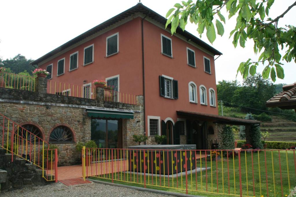 une maison avec une clôture devant dans l'établissement Podere Gianpaolo, à Pescia