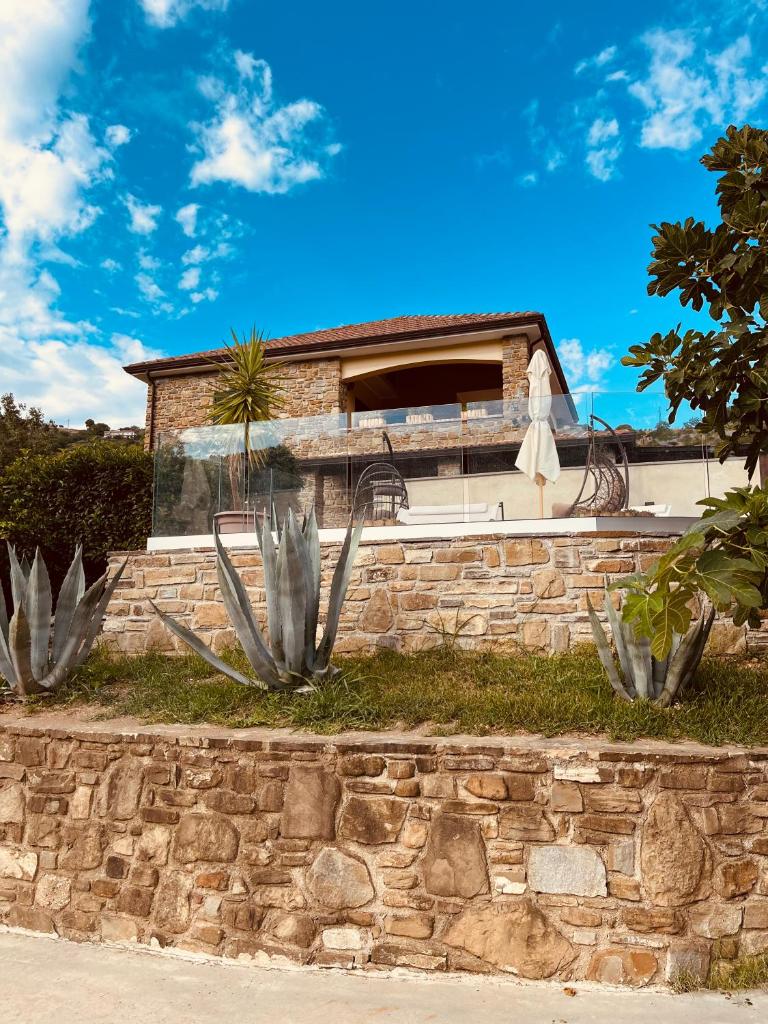 une maison avec un mur de pierre et des cactus dans l'établissement Villa Edda residenza con piscina, à Castellabate