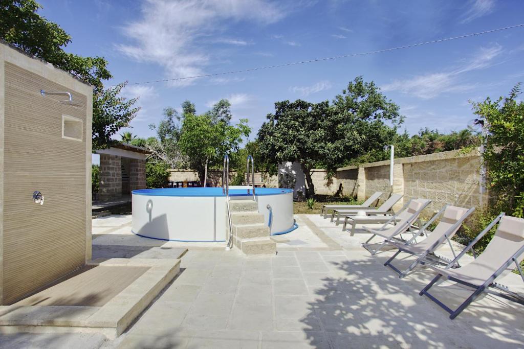 une terrasse avec des chaises longues et une piscine dans l'établissement Dimora Maniva, à Parabita