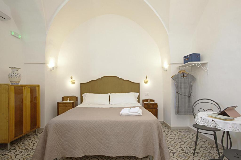 une chambre avec un lit et une table avec un ordinateur portable dans l'établissement Dimora Maniva, à Parabita