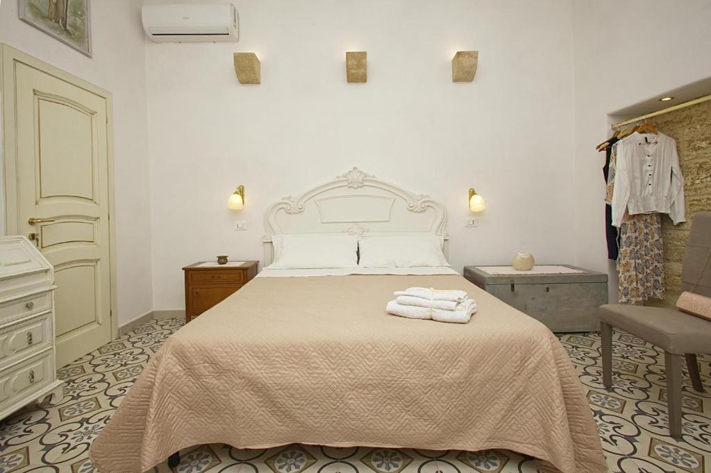 une chambre avec un lit avec deux serviettes dessus dans l'établissement Dimora Maniva, à Parabita 33 autres photos