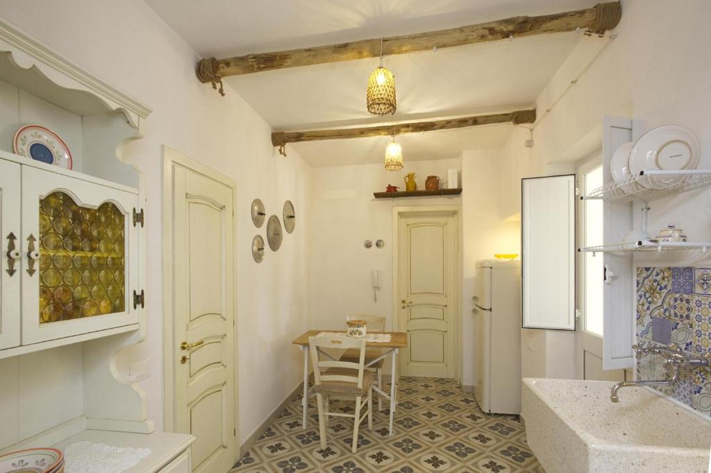 une cuisine avec une table et une chaise dans une pièce dans l'établissement Dimora Maniva, à Parabita