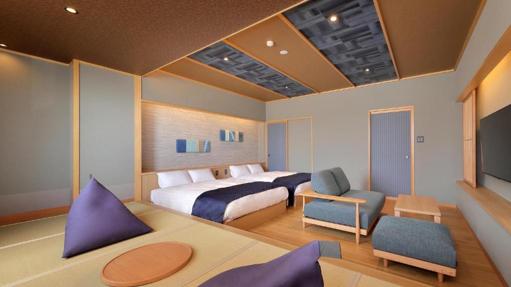 une chambre avec un lit et un salon dans l'établissement かっぱの宿旅館三治郎, à Zao