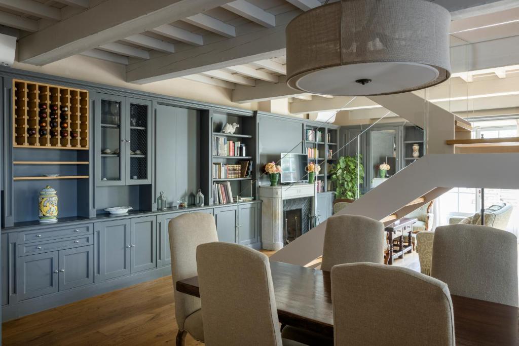 - une salle à manger avec des armoires bleues, une table et des chaises dans l'établissement Villa le Cipresse, à Impruneta