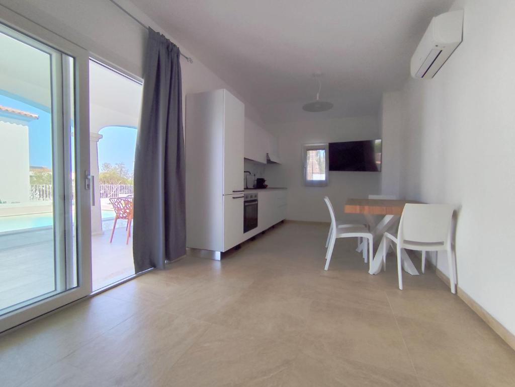 une cuisine et une salle à manger avec une table et des chaises dans l'établissement Villa il borgo con piscina, à Budoni