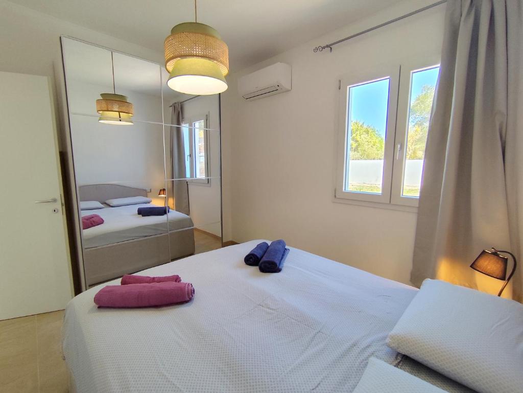 une chambre avec deux lits et un miroir dans l'établissement Villa il borgo con piscina, à Budoni