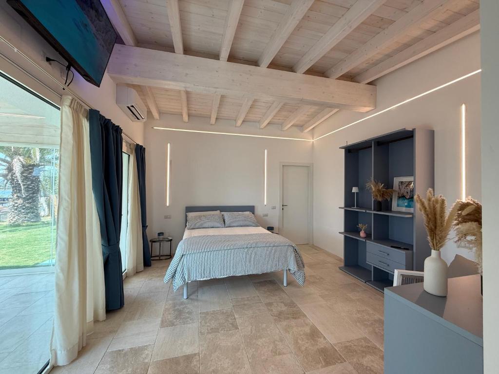 une chambre avec un lit et une grande fenêtre dans l'établissement Baia del Sole Resort, à Olbia