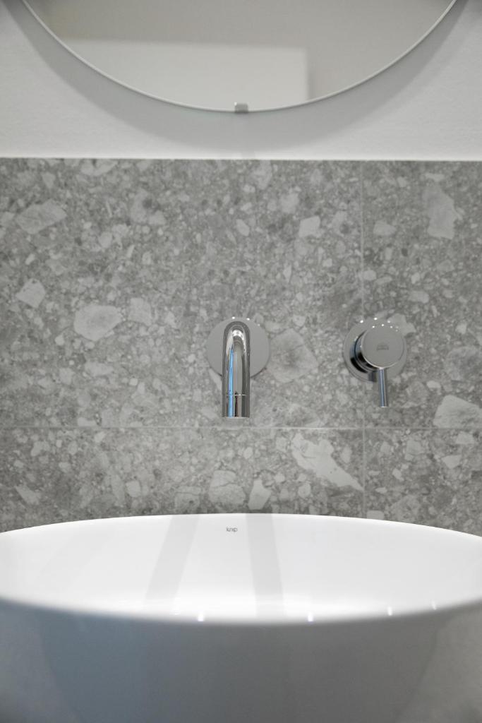 une salle de bain avec un lavabo blanc et une douche dans l'établissement Hotel Benvenuto, à Caorle