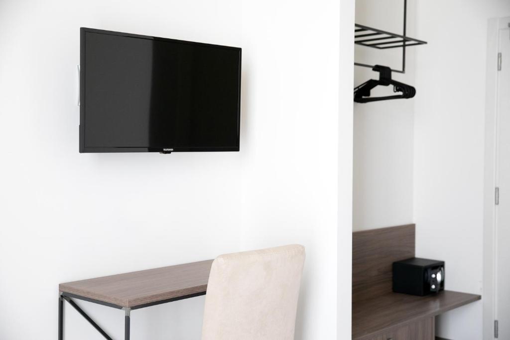 un salon avec une télévision sur un mur dans l'établissement Hotel Benvenuto, à Caorle 100 autres photos