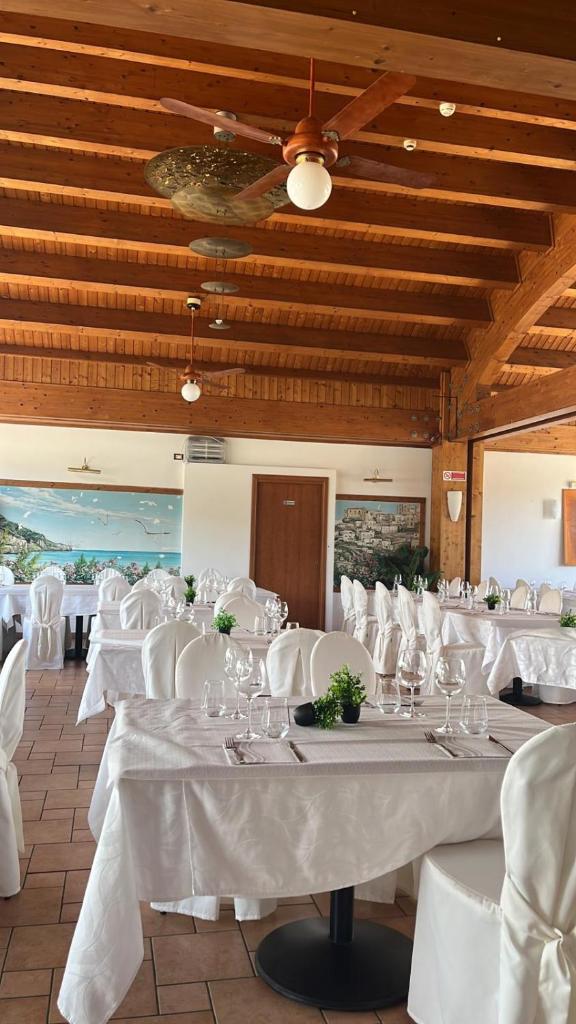 une salle à manger avec des tables blanches et des chaises blanches dans l'établissement Hotel Incontro, à Peschici