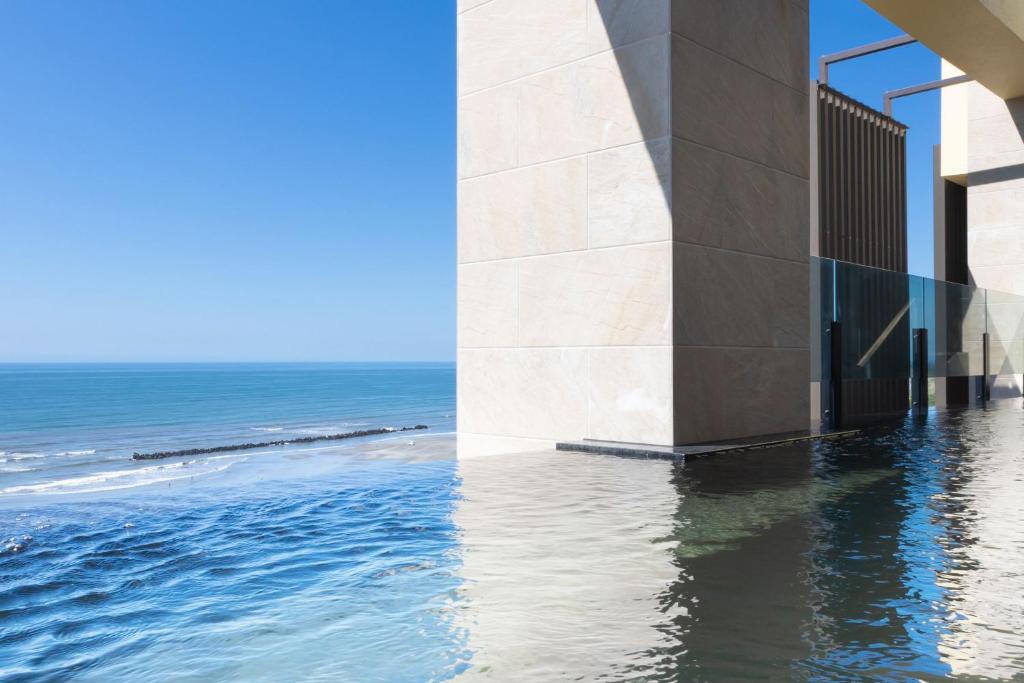 une vue sur l'océan depuis le côté d'un bâtiment dans l'établissement KAMENOI HOTEL Kujukuri, à Asahi