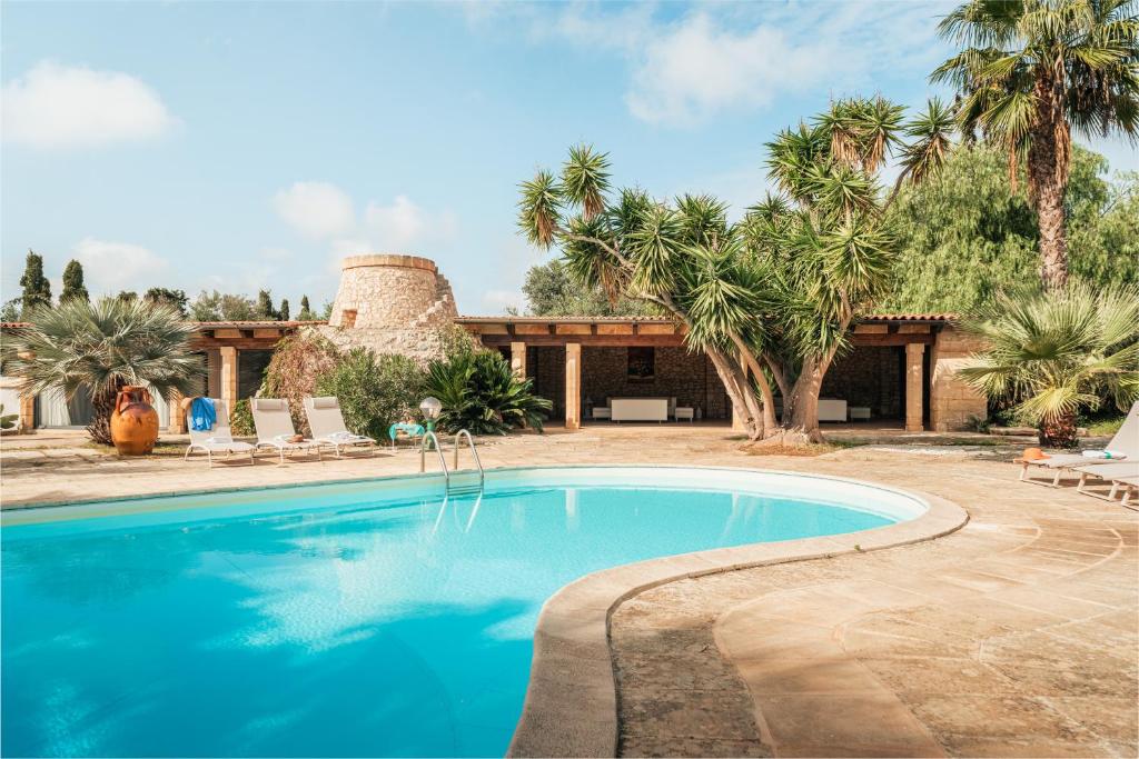 une piscine devant une maison avec des palmiers dans l'établissement Villa Manco 12, Emma Villas, à Gagliano del Capo