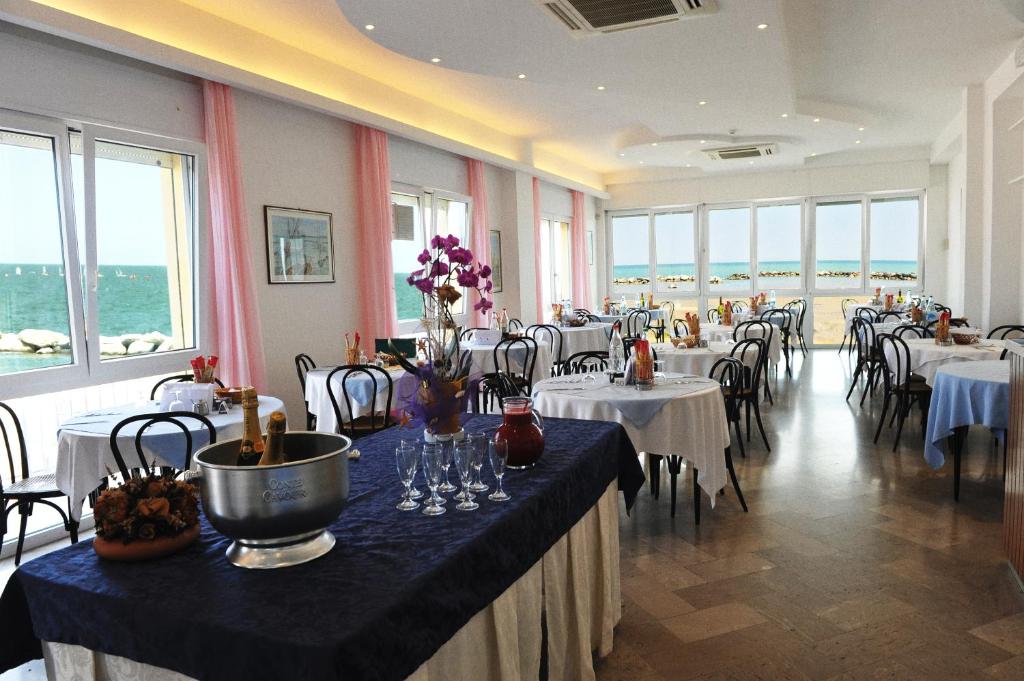une salle à manger avec tables et chaises et tablesearcher dans l'établissement Hotel Biagini, à Rimini