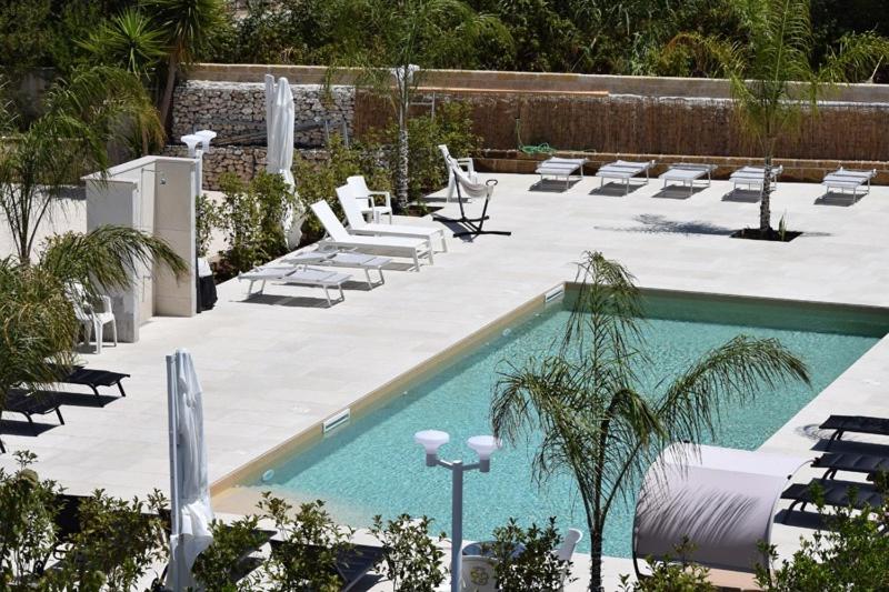 une piscine avec des chaises longues et une piscine dans l'établissement Hotel Incontro, à Peschici